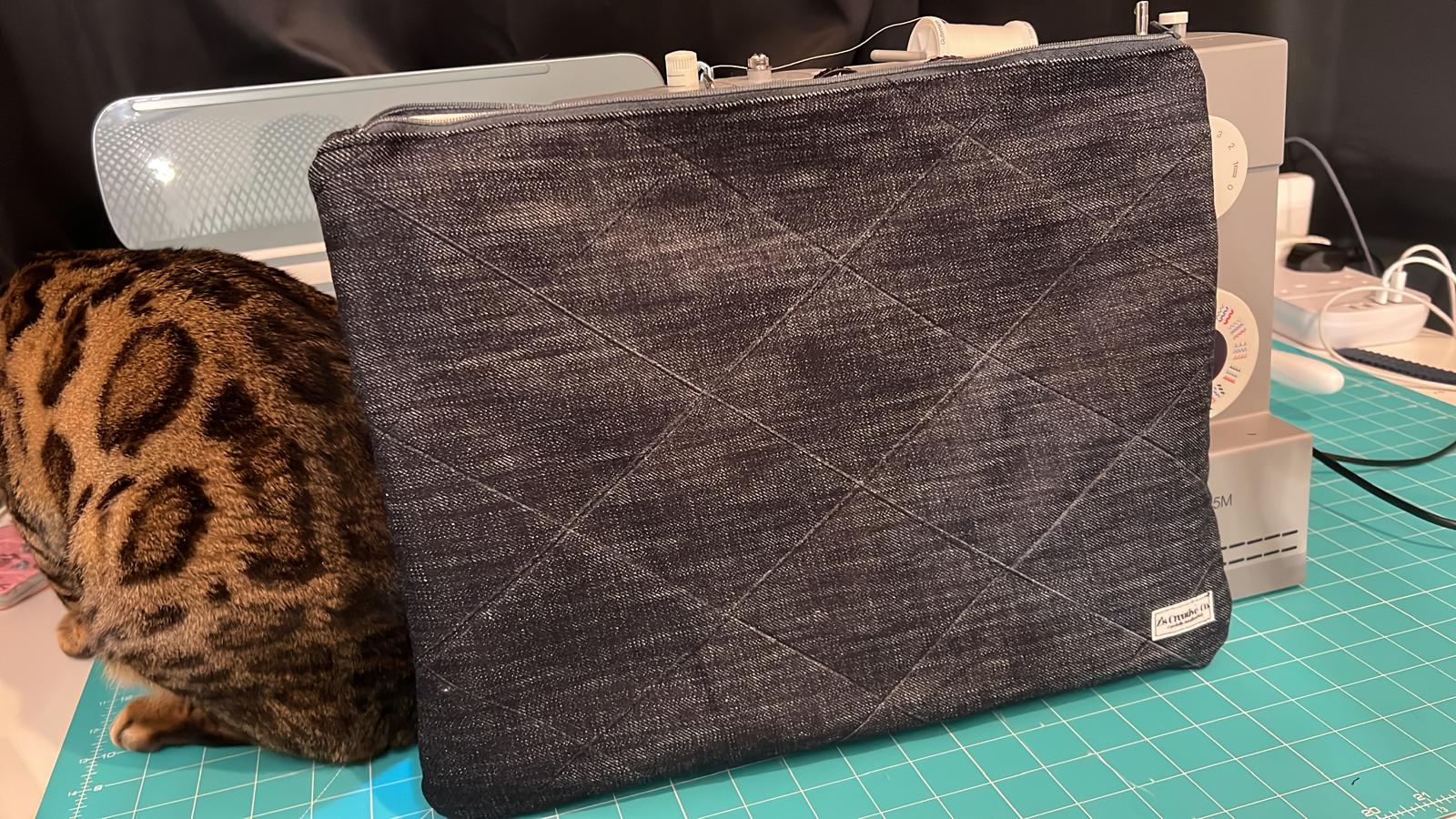 Bengal cat inspecting a handmade quilted laptop sleeve